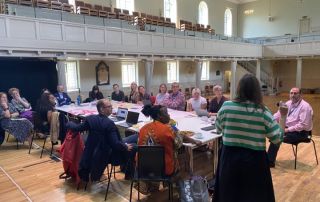 Photo from the Culture Board meeting, quarter two of 2024, with board members discussing the culture strategy around a table at St George's, Bristol.